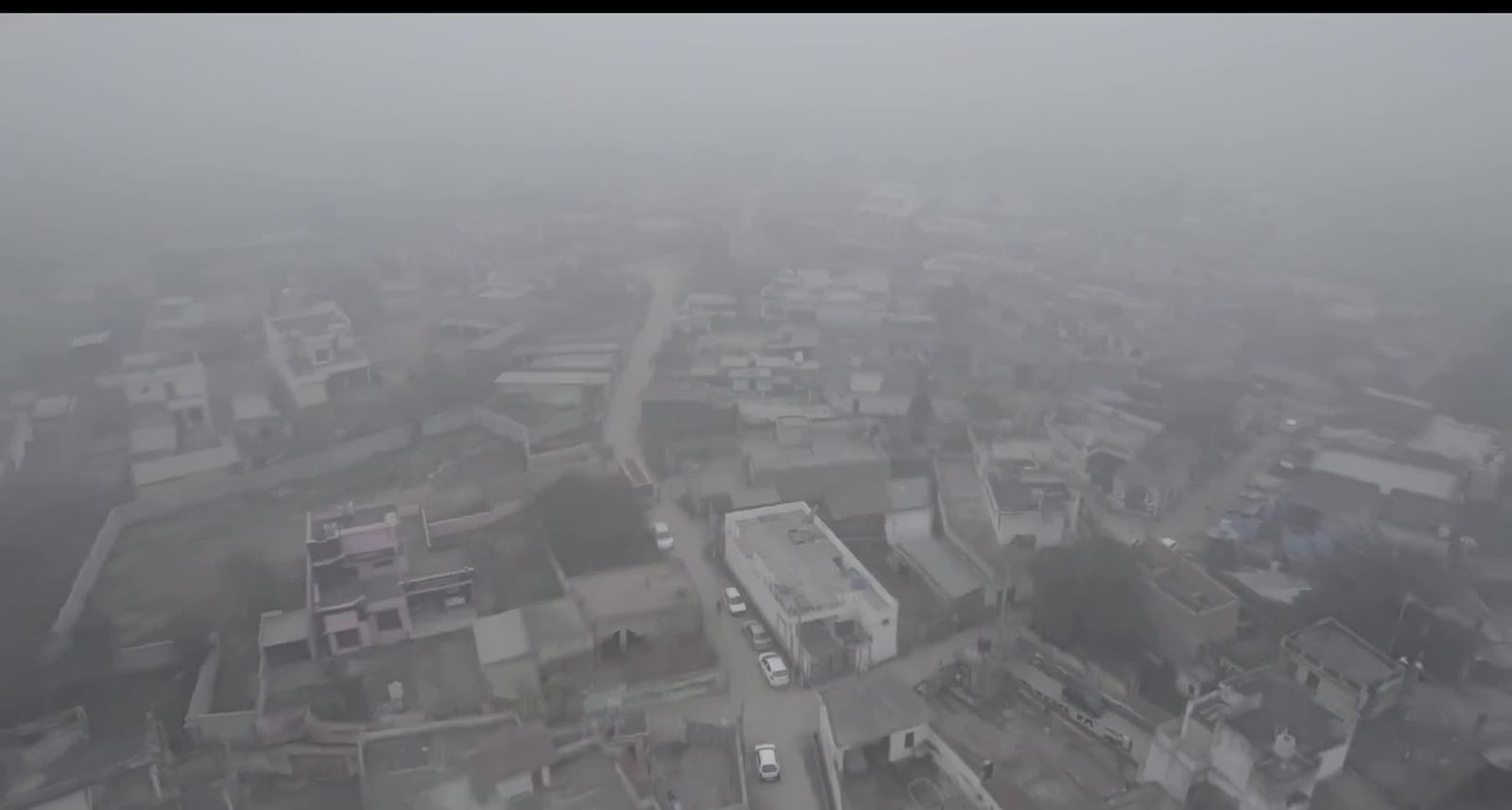 An aerial view of Delhi with its streets and rooftops lost in grey smog.